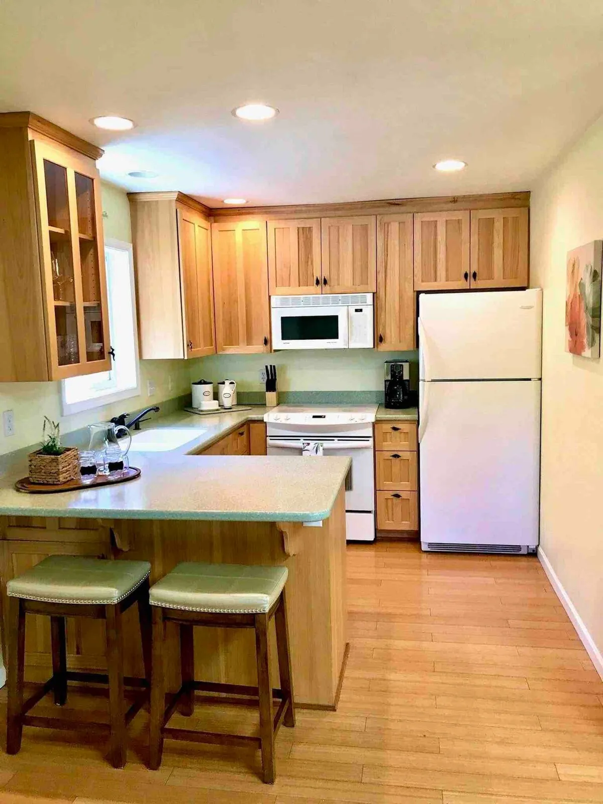 A warm, inviting kitchen featuring a kitchen island with stools, modern cabinets, and stainless steel appliances. The scene is set for both cooking and casual dining, with plenty of space for meal prep and socializing.